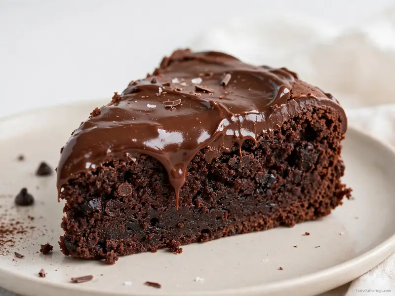 Fudgy brownie cake slice with chocolate frosting.